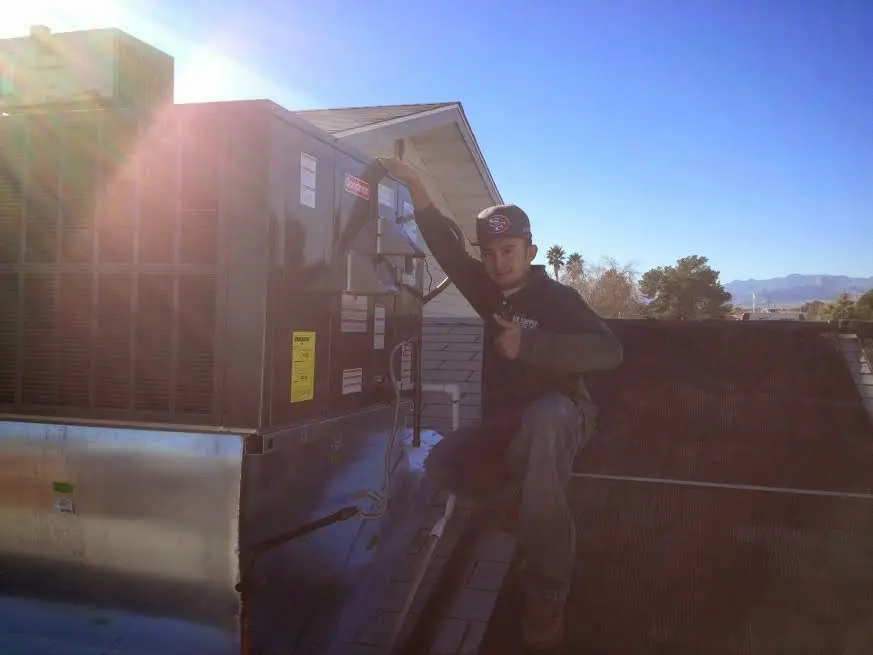 HVAC technician performing HVAC Inspection on a rooftop unit in Irondale